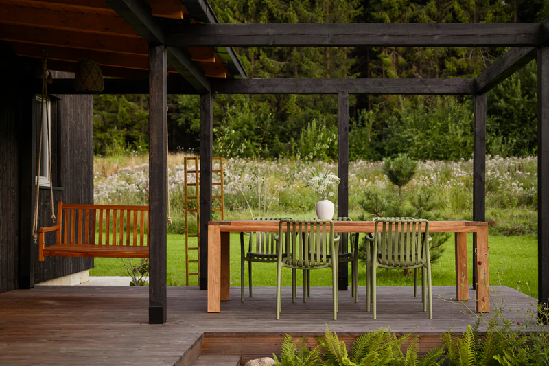 Wooden pergola with a garden table overlooking the meadow at Salinko